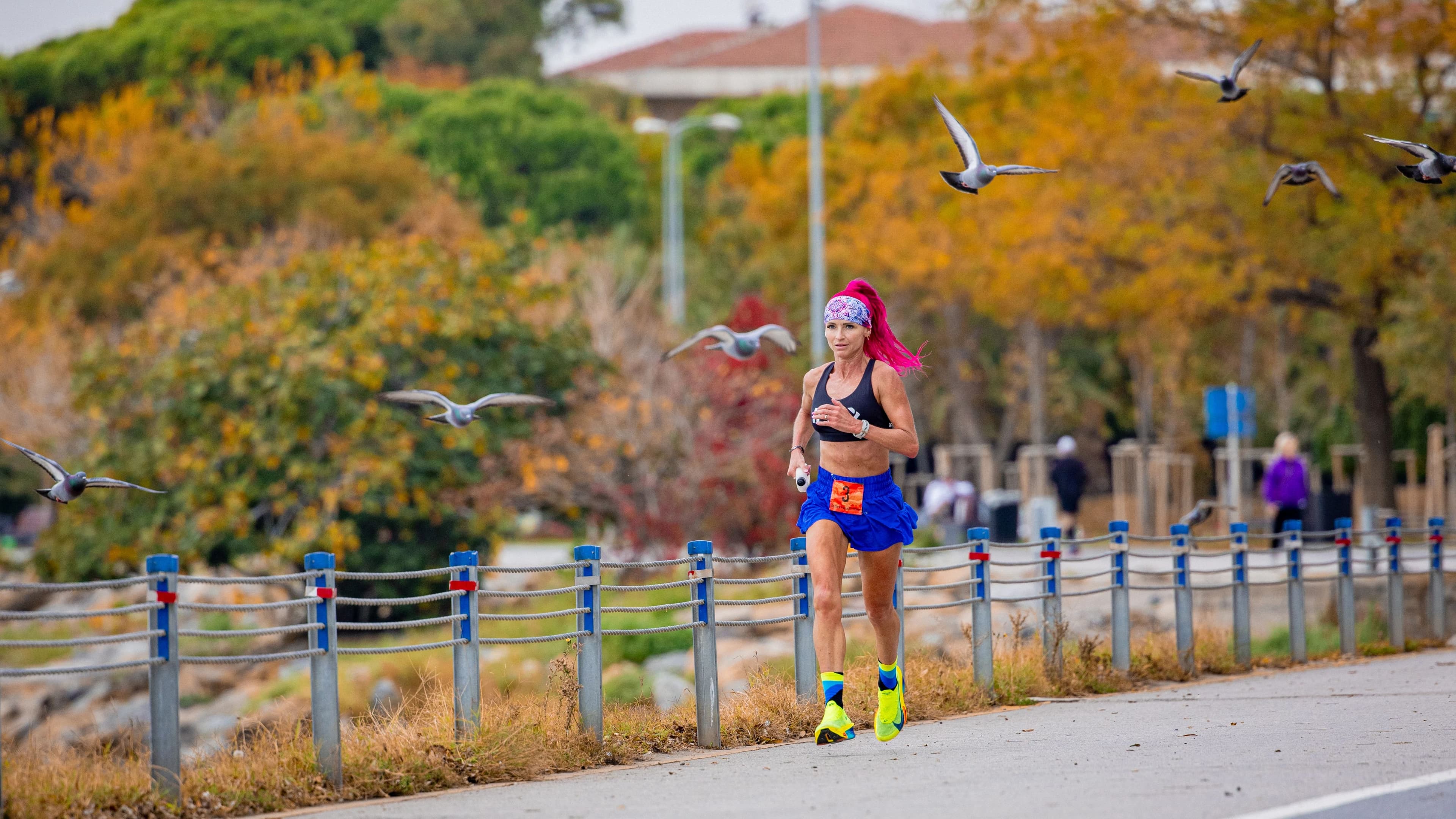 iFIT Trainer Ashley Paulson runs with a handheld water bottle, reflecting the hydration and fueling strategy covered in this guide.